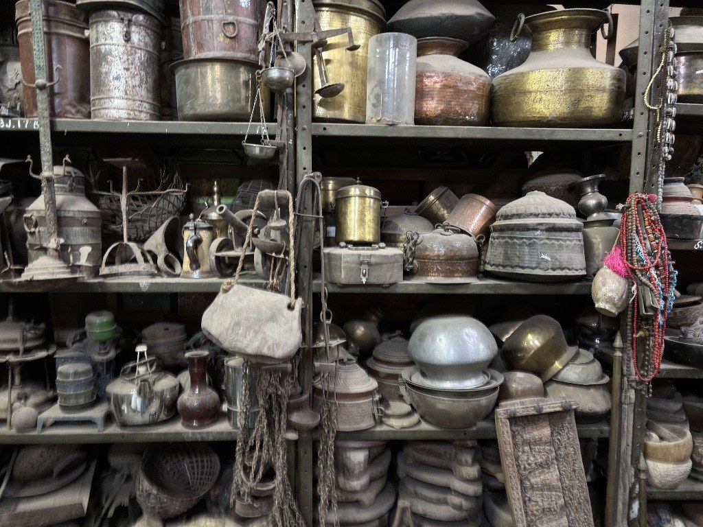 Authentic vintage Indian brass vessels, copper pots, hanging scales, and metalware in warehouse